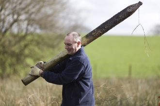 Volunteers at bagmere carrying old fence post