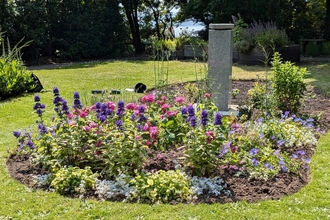 Flower bed at Hill House Gardens on a sun day with pink and purple flowers.