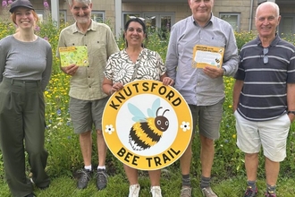 Members of the Knutsford NAP holding a giant bee trail sign