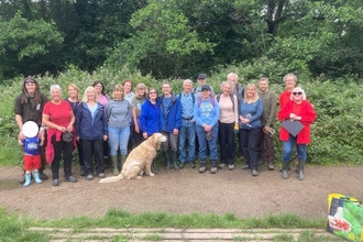 The community group called Friend's of LadyBrook Valley stand in a line smiling at the camera with a golden retriever dog in the middle.