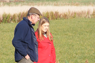 two people having a conversation on a farm