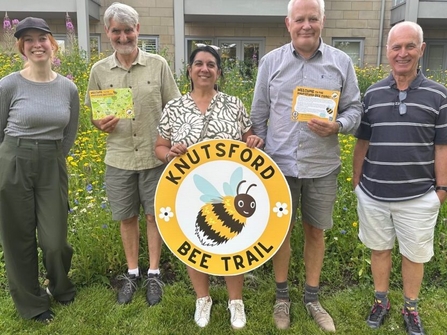 Members of the Knutsford NAP holding a giant bee trail sign