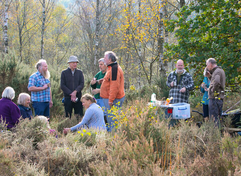 Volunteers in a woodland having a tea break